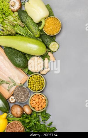 Balanced food set, green vegetables, seeds nuts, chicken meat. Diet  food. Flat lay, gray background. Copy space Stock Photo