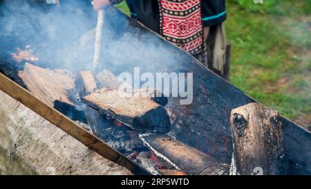 MASHANTUCKET RESERVATION, CT, USA-AUGUST 26, 2023: Making wooden boat with fire, close up Stock Photo