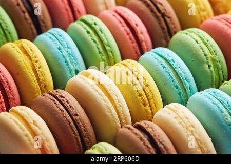 French colorful macarons background. Variety of colorful french sweet dessert macaron with different fillings. Stock Photo