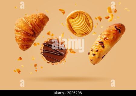 Freshly baked croissant and sweet pastries flying in air. Sweet dessert. Baked goods. Stock Photo