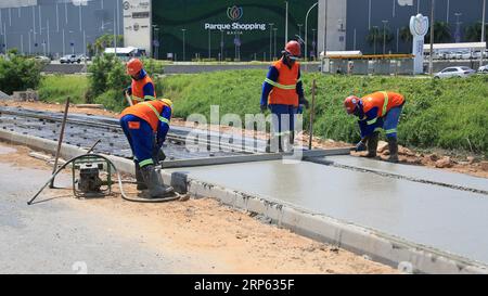 lauro de freitas, bahia, brazil - august 30, 2023: Construction workers are seen making concrete pavement on a sidewalk. Stock Photo