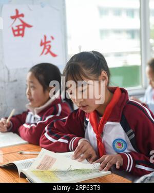 (190101) -- JULIAN, JAN. 1, 2019 (Xinhua) -- Li Xinqin (R) of the basketball team reads the textbook during a Chinese class at Haoba central school in Junlian County of Yibin City in southwest China s Sichuan Province, on Dec. 7, 2018. Situated in the vast Wumeng Mountains of southwest China s Sichuan Province, Haoba central school is a nine-year school providing primary education and middle school education, just like other schools in this mountain area. However, a basketball team formed by female students made the school quite famous in its township, even in neighboring cities. The team was Stock Photo
