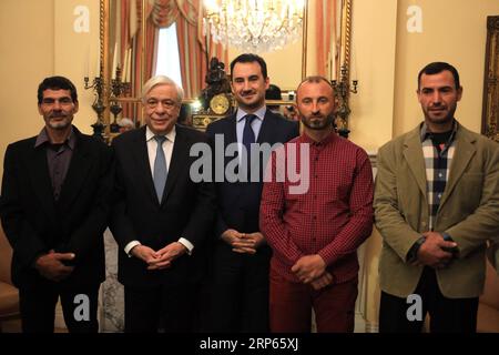 (190103) -- ATHENS, Jan. 3, 2019 -- Greek President Prokopis Pavlopoulos(2nd, left) and Alexis Charitsis(3rd,left), Greek Minister of Interior, poses for a group photo with the three fishermen at the presidential mansion in Athens, Greece, Jan. 2, 2019. Egyptians Emand El Khamisi, 50, Mahmoud Moussa, 46, and Albanian Jeka Gani, 35, risked their lives alongside many other local fishermen on July 23, 2018 rescuing dozens of people fleeing the blaze which swept through the seaside resort of Mati, some 30 kilometers northeast of Athens. One hundred people died in the flames or the sea that evening Stock Photo