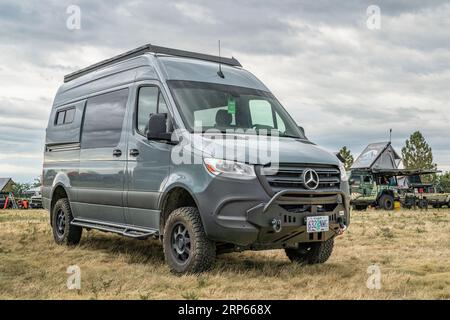 Loveland, CO, USA - August 25, 2023: 4x4 camper van on Mercedes Sprinter chassis with a custom front bumper and winch at a busy campground. Stock Photo
