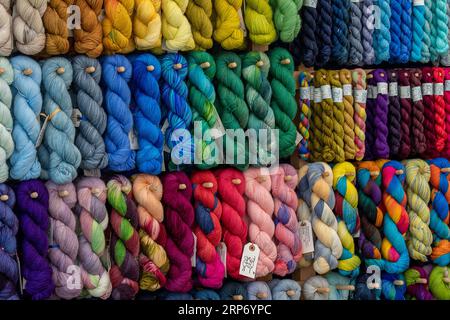 selection of multi-coloured skeins of coloured wool on display in a wool and craft knitting shop. Stock Photo