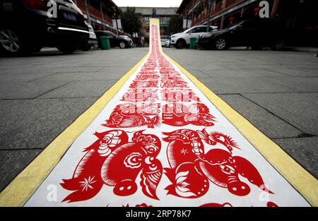 (190131) -- ZAOZHUANG, Jan. 31, 2019 (Xinhua) -- Folk artist Shi Hongxia shows a pig-themed paper cutting artwork in Tengzhou City, east China s Shandong Province, Jan. 31, 2019. Shi has spent two months to create the artwork, which is 9 meters long and features 100 pig figures, to greet the coming of the Year of the Pig. (Xinhua/Sun Zhongzhe) CHINA-SHANDONG-SPRING FESTIVAL-PAPER-CUTTING ARTWORK (CN) PUBLICATIONxNOTxINxCHN Stock Photo