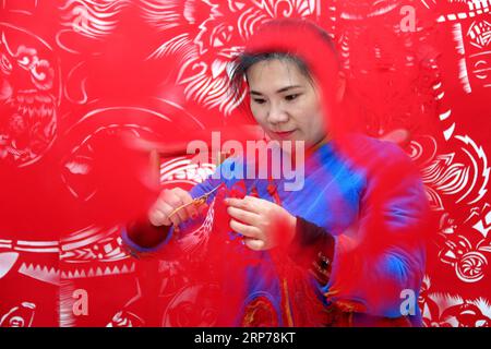 (190131) -- ZAOZHUANG, Jan. 31, 2019 (Xinhua) -- Folk artist Shi Hongxia creates a pig-themed paper cutting artwork at home in Tengzhou City, east China s Shandong Province, Jan. 31, 2019. Shi has spent two months to create the artwork, which is 9 meters long and features 100 pig figures, to greet the coming of the Year of the Pig. (Xinhua/Sun Zhongzhe) CHINA-SHANDONG-SPRING FESTIVAL-PAPER-CUTTING ARTWORK (CN) PUBLICATIONxNOTxINxCHN Stock Photo