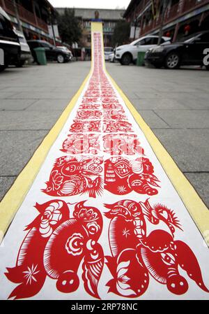 (190131) -- ZAOZHUANG, Jan. 31, 2019 (Xinhua) -- Folk artist Shi Hongxia shows a pig-themed paper cutting artwork in Tengzhou City, east China s Shandong Province, Jan. 31, 2019. Shi has spent two months to create the artwork, which is 9 meters long and features 100 pig figures, to greet the coming of the Year of the Pig. (Xinhua/Sun Zhongzhe) CHINA-SHANDONG-SPRING FESTIVAL-PAPER-CUTTING ARTWORK (CN) PUBLICATIONxNOTxINxCHN Stock Photo