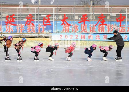 (190201) -- BEIJING, Feb. 1, 2019 (Xinhua) -- Photo taken on Jan. 9, 2019 shows studnets practicing with their coach Li Chunyu (1st R) during a skating training session at Taipingzhuang Central Primary School, in Yanqing District of Beijing, capital of China. Taipingzhuang Central Primary School situated right at the foot of Xiaohaituo Mountains, where the venues for Beijing 2022 Winter Olympic games are under construction. Teachers of Taipingzhuang Central Primary School have turned an experimental farmland into a seasonal skating rink for the pupils here to learn skating since 2016. The scho Stock Photo