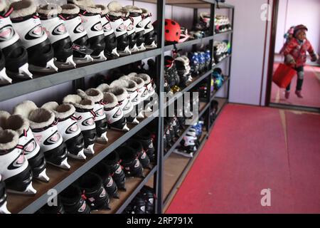 (190201) -- BEIJING, Feb. 1, 2019 (Xinhua) -- Photo taken on Jan. 10, 2019 shows a student running into the locker room where the skating shoes are stored on the shelves at Taipingzhuang Central Primary School, in Yanqing District of Beijing, capital of China. Taipingzhuang Central Primary School situated right at the foot of Xiaohaituo Mountains, where the venues for Beijing 2022 Winter Olympic games are under construction. Teachers of Taipingzhuang Central Primary School have turned an experimental farmland into a seasonal skating rink for the pupils here to learn skating since 2016. The sch Stock Photo