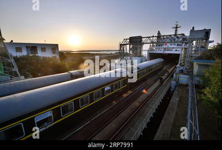 (190201) -- HAIKOU, Feb. 1, 2019 (Xinhua) -- Aerial photo shows train cabins with passengers inside are towed onto the ferry at Nangang Port in Haikou, capital of south China s Hainan Province, Jan. 31, 2019. Some people back home to Hainan Province during the Spring Festival travel rush take the Yuehai Railway Line. The Yuehai Railway Line, as the first cross-sea rail line in China, connects the island province of Hainan with Guangdong on the mainland by train ferry, a ferry carrying the detached train carriages across the sea. (Xinhua/Guo Cheng) CHINA-HAINAN-HAIKOU-CROSS-SEA RAILWAY (CN) PUB Stock Photo