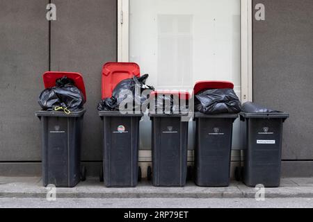 Symbolic image, symmetry, city cleaning, waste disposal, recycling, bins for residual waste filled with rubbish bags at the roadside in Hamburg Stock Photo