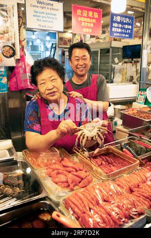 Korean woman and Korean man with a crab, Gwangjang market, traditional street market in Jongno-gu, Seoul, South Korea Stock Photo