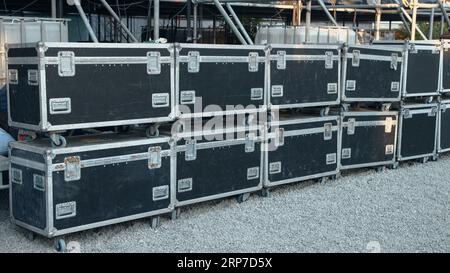 Two rows of black transport boxes for music equipment backstage at a music concert Stock Photo