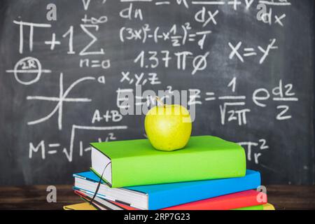 Apple books pile near chalkboard Stock Photo