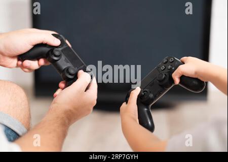 Front view father son playing controllers Stock Photo