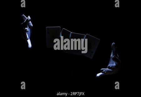 Magician s hand performing trick with playing card Stock Photo