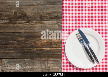 White plate checkered table cloth wooden textured plank Stock Photo