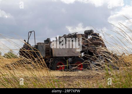 Burnt-out combine harvester, Steinbergkirche, Schleswig-Holstein, Germany Stock Photo