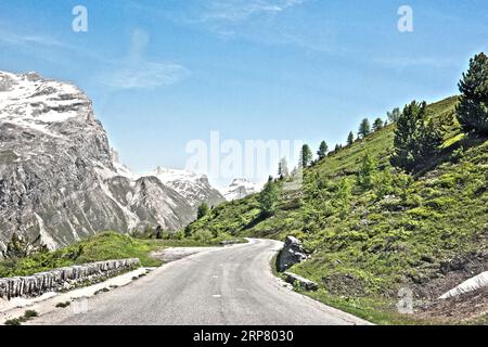 Photo with reduced dynamic range saturation HDR of mountain pass alpine mountain road alpine road pass road pass near tree line in landscape of high Stock Photo