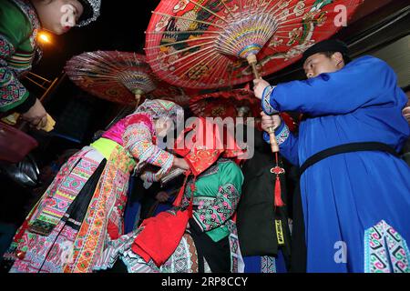 (190227) -- XINGWEN, Feb. 27, 2019 (Xinhua) -- Bride Han Yujie(sitting) is attended to change her clothes as the team moved near the groom s house in Xingwen County, southwest China s Sichuan province, Feb. 26, 2019. Yang Yuqiao and Han Yujie, an ethnic Miao couple, tied the knot in traditional Miao style in Wenxing County, southwest China s Sichuan province, Feb. 24-26, 2019. Yang Yuqiao, the 25 year-old groom, works as a tour guide in Xingwen UNESCO Global Geopark, and Han Yujie, the 23 year-old bride, works as a PE teacher in Dahe Miao Township in Xingwen County. During the volunteering wor Stock Photo