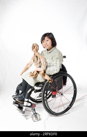 (190301) -- BEIJING, March 1, 2019 (Xinhua) -- Huang Jing, 39, diagnosed with spina bifida, poses for a portrait in Beijing, capital of China, Feb. 26, 2019. Huang Jing went through a lot of trouble in finding a job due to her disability. There was a time of distress when she had few money left with her and she could not find another way out but to sell newspapers at a bus station. Huang decides to face every dilemma with determination to follow her heart and step into the society. Rare Hug, a Chinese drama on rare diseases, was staged at the Beijing Tianqiao Performing Arts Center Wednesday e Stock Photo