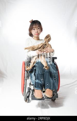 190301 -- BEIJING, March 1, 2019 Xinhua -- Yin Yuanyue, 29, diagnosed with muscular dystrophy, poses for a portrait in Beijing, capital of China, Feb. 26, 2019. Spending most time on her childhood fighting against disease, Yin could not step out from home for over a decade. When she was 24, she for the first time took on all the courage and went on a trip to Dalian of northeast China s Liaoning Province. This experience allowed her to see the world from a brand new perspective and to embrace her colorful life. Rare Hug, a Chinese drama on rare diseases, was staged at the Beijing Tianqiao Perfo Stock Photo