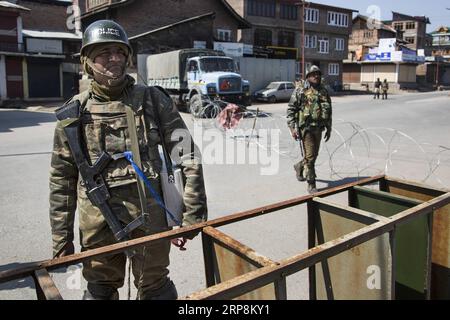 (190310) -- SRINAGAR, March 10, 2019 (Xinhua) -- Indian paramilitary soldiers stand guard near a barricade during a security lockdown in downtown area of Srinagar, the summer capital of Indian-controlled Kashmir, March 10, 2019. Authorities on Sunday imposed restrictions in parts of Srinagar city to prevent protests after India s anti-terror agency, National Investigation Agency (NIA), summoned key separatist leader and chief cleric of Indian-controlled Kashmir for questioning in an alleged funding case, officials said on Saturday. Mirwaiz Umar Farooq has been asked to appear before the probe Stock Photo