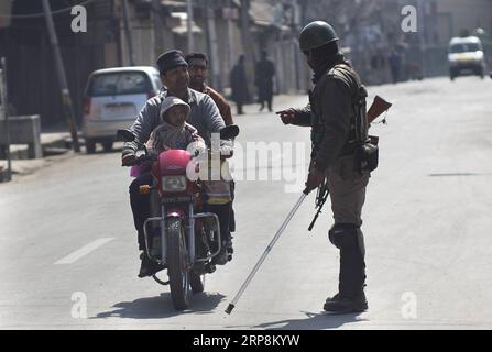 (190310) -- SRINAGAR, March 10, 2019 (Xinhua) -- An Indian paramilitary soldier stops a motorcyclist during a security lockdown in downtown area of Srinagar, the summer capital of Indian-controlled Kashmir, March 10, 2019. Authorities on Sunday imposed restrictions in parts of Srinagar city to prevent protests after India s anti-terror agency, National Investigation Agency (NIA), summoned key separatist leader and chief cleric of Indian-controlled Kashmir for questioning in an alleged funding case, officials said on Saturday. Mirwaiz Umar Farooq has been asked to appear before the probe agency Stock Photo