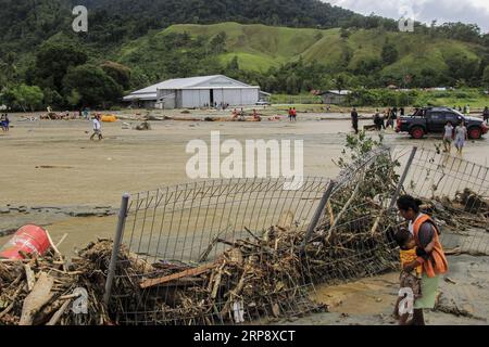 News Themen der Woche KW11 News Bilder des Tages 190317 -- SENTANI, March 17, 2019 -- A mother holds her child near a collapsed fence after flash floods in Sentani, Indonesia, on March 17, 2019. Sixty-three bodies have been retrieved after flash floods hit Indonesia s easternmost Papua province on Saturday night, and a search and rescue operation is still ongoing for dozens still missing, a rescue team member said on Sunday.  INDONESIA-SENTANI-FLASH FLOOD Ikha PUBLICATIONxNOTxINxCHN Stock Photo