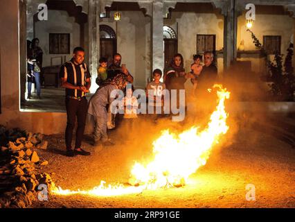 (190320) -- QESHM ISLAND, March 20, 2019 -- People stand around a bonfire in the celebrations of the fire festival in Qeshm Island, southern Iran, on March 19, 2019. The fire festival, a 4,000-year Persian tradition, is celebrated by Iranians on the eve of the last Wednesday before Nowruz (the Iranian new year). ) IRAN-QESHM ISLAND-FIRE FESTIVAL AhmadxHalabisaz PUBLICATIONxNOTxINxCHN Stock Photo