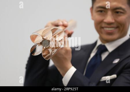 (190321) -- BEIJING, March 21, 2019 (Xinhua) -- Tokyo 2020 Torch Relay Ambassador, Japanese athlete Tadahiro Nomura shows the design of the Tokyo 2020 Olympic Torch in Tokyo, Japan, on March 20, 2019. The Tokyo Organising Committee of the Olympic and Paralympic Games (Tokyo 2020) unveiled the prototype of the Tokyo 2020 Olympic Torch on Wednesday. The motif of Tokyo 2020 Olympic Torch is cherry blossom. Aluminum recycled from temporary housing used in areas struck by the Great East Japan Earthquake disaster will be used to manufacture the torch. (Xinhua/Du Xiaoyi) XINHUA PHOTOS OF THE DAY PUBL Stock Photo