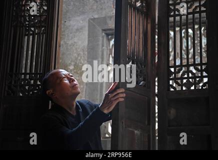 (190324) -- WUYUAN, March 24, 2019 (Xinhua) -- Yu Youhong checks a part of an ancient building in Wangkou Village, Wuyuan County of east China s Jiangxi Province, March 19, 2019. The Three Carvings in Wuyuan , including carvings on stones, bricks and wood, was listed as one of China s national intangible cultural heritages in 2006. As decorating carvings on buildings during ancient Ming and Qing dynasties in Wuyuan of east China s Jiangxi, the carvings take materials with high quality and demand high standards of handicraft, displaying the features of local culture. Yu Youhong, a national-leve Stock Photo