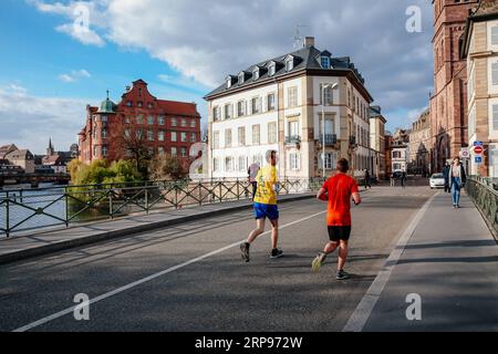 (190327) -- PARIS, March 27, 2019 (Xinhua) -- Two men run on the street in Strasbourg, France, March 26, 2019. (Xinhua/Zhang Cheng) FRANCE-STRASBOURG-SPRING PUBLICATIONxNOTxINxCHN Stock Photo
