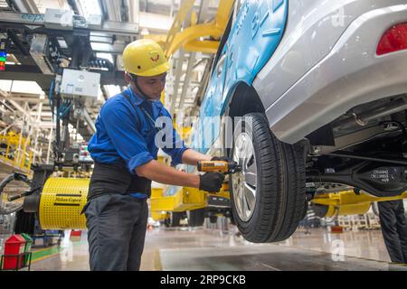 A Chinese worker assembles cars on the assembly line at an auto plant ...