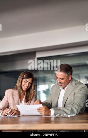 Two happy professional executives discussing financial documents in office. Stock Photo