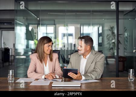 Two professional business executives working on tablet at office meeting. Stock Photo
