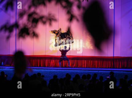 (190414) -- BANGKOK, April 14, 2019 (Xinhua) -- An artist performs Nang Yai, a shadow puppet performance, at Wat Khanon in Ratchaburi Province, Thailand, April 13, 2019. Nang yai is a form of shadow play found in Thailand and Cambodia. Puppets are made of painted buffalo hide, while the story is narrated by songs, chants and music. (Xinhua/Zhang Keren) THAILAND-RATCHABURI-SHADOW PUPPET PUBLICATIONxNOTxINxCHN Stock Photo