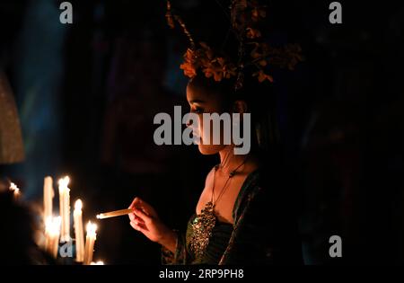 (190414) -- BANGKOK, April 14, 2019 (Xinhua) -- An artist lights up candles for the Nang yai shadow puppet performance at Wat Khanon in Ratchaburi Province, Thailand, April 13, 2019. Nang yai is a form of shadow play found in Thailand and Cambodia. Puppets are made of painted buffalo hide, while the story is narrated by songs, chants and music. (Xinhua/Zhang Keren) THAILAND-RATCHABURI-SHADOW PUPPET PUBLICATIONxNOTxINxCHN Stock Photo