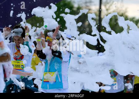 (190421) -- BUCHAREST, April 21, 2019 -- People participate in a color run event in Bucharest, Romania, on April 20, 2019. (SP)ROMANIA-BUCHAREST-COLOR RUN (Xinhua/CristianxCristel) PUBLICATIONxNOTxINxCHN Stock Photo