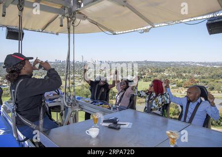 (190427) -- JOHANNESBURG, April 27, 2019 (Xinhua) -- Guests pose for photos at the Sky Table in Johannesburg, South Africa, April 27, 2019. The Sky Table, capable of accommodating 22 guests, is on a platform suspended at a height of 50 meters in St Stithians College. (Xinhua/Chen Cheng) SOUTH AFRICA-JOHANNESBURG-SKY RESTAURANT PUBLICATIONxNOTxINxCHN Stock Photo