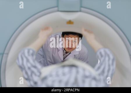 (190504) -- WUHAN, May 4, 2019 (Xinhua) -- Zhou Xin checks the condition of a patient to be tested at a laboratory at Wuhan Institute of Physics and Mathematics of Chinese Academy of Sciences in Wuhan, capital of central China s Hubei Province, April 18, 2019. Professor Zhou Xin is the deputy director of Wuhan Institute of Physics and Mathematics of Chinese Academy of Sciences, State Key Laboratory of Magnetic Resonance and Atomic and Molecular Physics, and National Center for Magnetic Resonance in Wuhan. He is interested in ultrasensitive magnetic resonance imaging (MRI) instruments, techniqu Stock Photo