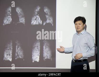 (190504) -- WUHAN, May 4, 2019 (Xinhua) -- Zhou Xin poses for a photo with human lung magnetic resonance images at Wuhan Institute of Physics and Mathematics of Chinese Academy of Sciences in Wuhan, capital of central China s Hubei Province, April 19, 2019. Professor Zhou Xin is the deputy director of Wuhan Institute of Physics and Mathematics of Chinese Academy of Sciences, State Key Laboratory of Magnetic Resonance and Atomic and Molecular Physics, and National Center for Magnetic Resonance in Wuhan. He is interested in ultrasensitive magnetic resonance imaging (MRI) instruments, techniques Stock Photo