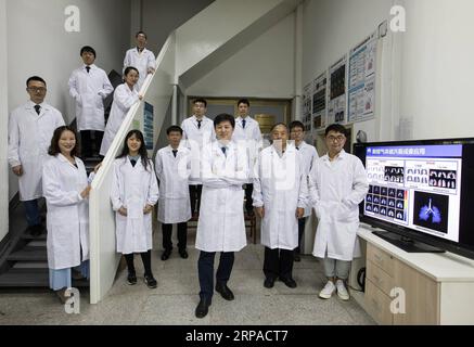 (190504) -- WUHAN, May 4, 2019 (Xinhua) -- Zhou Xin (3rd R, front) and core members of his group pose for a group photo at Wuhan Institute of Physics and Mathematics of Chinese Academy of Sciences in Wuhan, capital of central China s Hubei Province, April 19, 2019. Professor Zhou Xin is the deputy director of Wuhan Institute of Physics and Mathematics of Chinese Academy of Sciences, State Key Laboratory of Magnetic Resonance and Atomic and Molecular Physics, and National Center for Magnetic Resonance in Wuhan. He is interested in ultrasensitive magnetic resonance imaging (MRI) instruments, tec Stock Photo