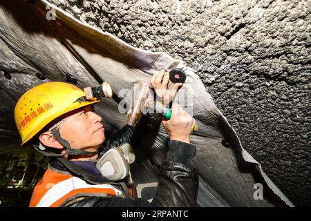 (190516) -- RUOQIANG, May 16, 2019 (Xinhua) -- Construction worker Zhong Yingxue operates waterproof task in the tunnel though Altun Mountains in Ruoqiang County, northwest China s Xinjiang Uygur Autonomous Region, May 15, 2019. The 13.195-kilometer-long tunnel through Altun Mountains is the longest tunnel of the Golmud-Korla railway line. The railway line, connecting Golmud in Qinghai and Korla in Xinjiang, is the third rail artery linking Xinjiang with neighboring provinces. The line will cut the traffic time between Golmud and Korla from 26 hours to 12 hours. (Xinhua/Ding Lei) CHINA-XINJIAN Stock Photo