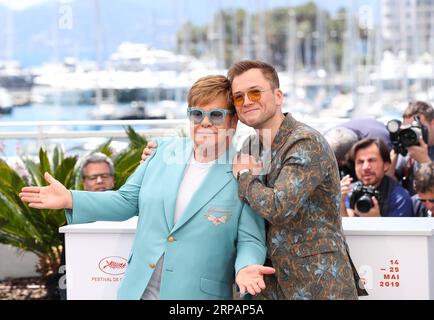 (190516) -- CANNES, May 16, 2019 (Xinhua) -- Producer Elton John and actor Taron Egerton pose during a photocall for the film Rocketman screened in the Hors Competition section during the 72nd Cannes Film Festival in Cannes, France, May 16, 2019. (Xinhua/Zhang Cheng) FRANCE-CANNES-FILM FESTIVAL-PHOTOCALL-ROCKETMAN PUBLICATIONxNOTxINxCHN Stock Photo