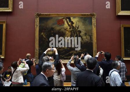 190517 -- BEIJING, May 17, 2019 Xinhua -- People take pictures of La Liberte guidant le peuple, or Liberty Leading the People, by Eugene Delacroix displayed at the Louvre Museum in Paris, France, May 15, 2019. Saturday marks the International Museum Day. Xinhua/Alexandre Karmen INTERNATIONAL MUSEUM DAY PUBLICATIONxNOTxINxCHN Stock Photo
