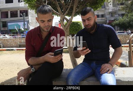 (190523) -- GAZA, May 23, 2019 -- Palestinian young men Amin Abed (R) and Mohammed al-Bourno use their phones to work on an online campaign in Gaza City, May 22, 2019. A group of Palestinian youths in the Gaza Strip have established an online campaign to refute the Israeli narration. TO GO WITH Feature: Palestinian youths launch campaign to refute Israeli narrations Stringer) MIDEAST-GAZA-ONLINE CAMPAIGN zhaoyue PUBLICATIONxNOTxINxCHN Stock Photo