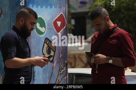 (190523) -- GAZA, May 23, 2019 -- Palestinian young men Amin Abed (R) and Mohammed al-Bourno use their phones to work on an online campaign in Gaza City, May 22, 2019. A group of Palestinian youths in the Gaza Strip have established an online campaign to refute the Israeli narration. TO GO WITH Feature: Palestinian youths launch campaign to refute Israeli narrations Stringer) MIDEAST-GAZA-ONLINE CAMPAIGN zhaoyue PUBLICATIONxNOTxINxCHN Stock Photo