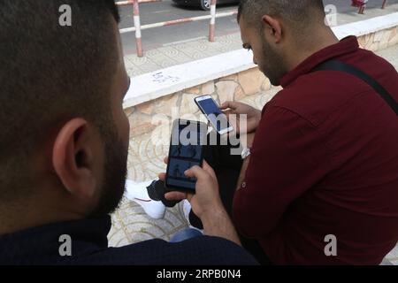 (190523) -- GAZA, May 23, 2019 -- Palestinian young men Amin Abed (R) and Mohammed al-Bourno use their phones to work on an online campaign in Gaza City, May 22, 2019. A group of Palestinian youths in the Gaza Strip have established an online campaign to refute the Israeli narration. TO GO WITH Feature: Palestinian youths launch campaign to refute Israeli narrations Stringer) MIDEAST-GAZA-ONLINE CAMPAIGN zhaoyue PUBLICATIONxNOTxINxCHN Stock Photo